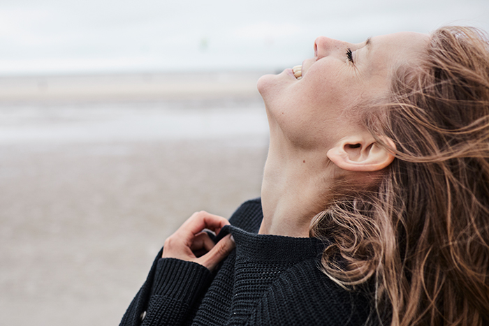 Frau l&auml;chelt am Strand