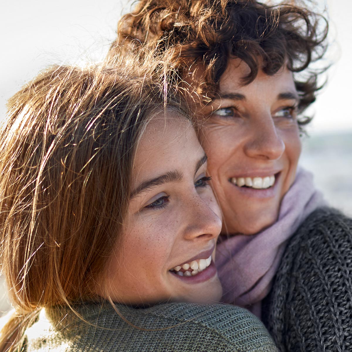 Mutter und Tochter halten sich lachend im Arm