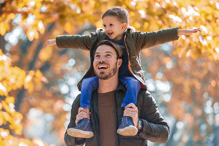 Vater traget Jungen auf den Schultern