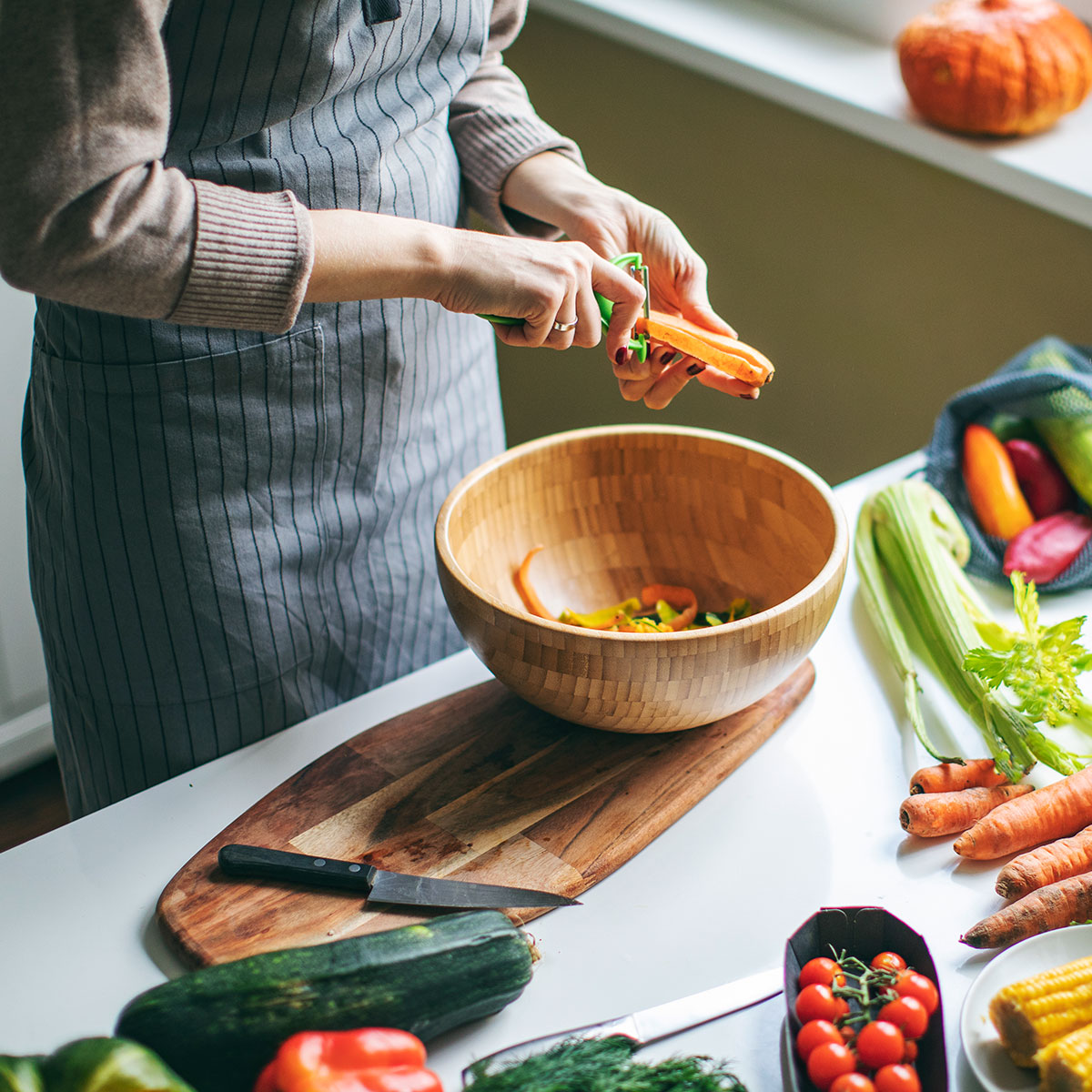 Frau schält Möhren