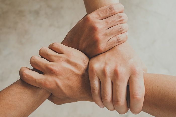 Drei ineinander veschlungenen H&auml;nde