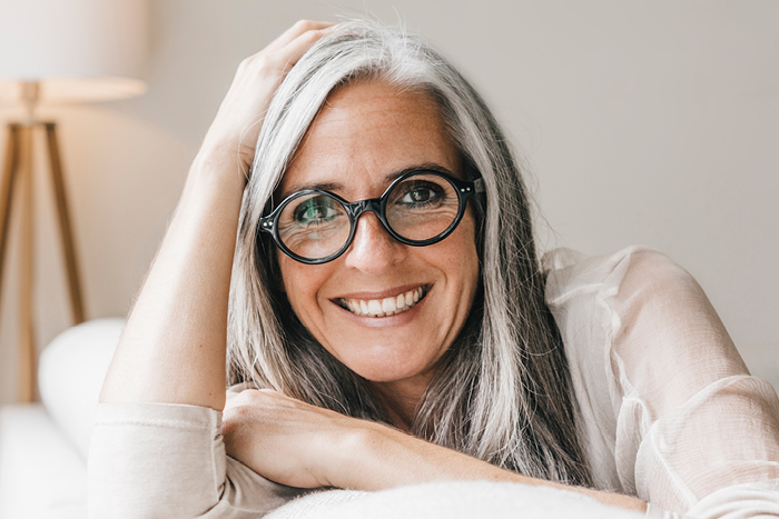 Frau mit schwarzer Brille l&auml;chelt in die Kamera