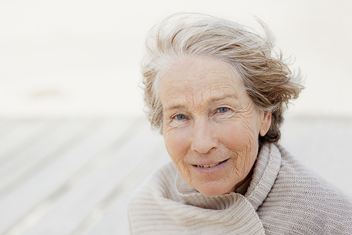 &Auml;ltere Frau l&auml;chelt in die Kamera