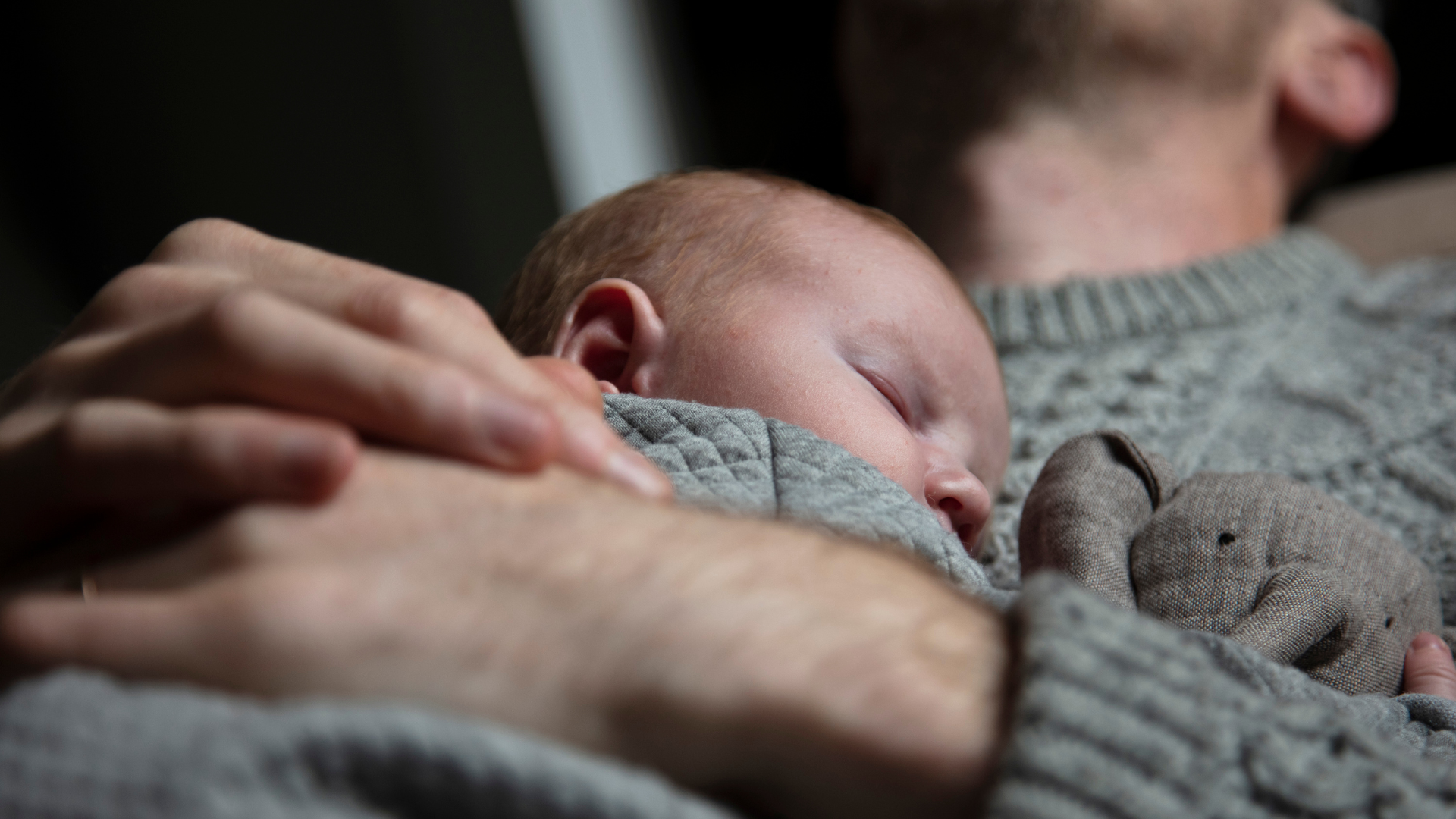 Vater hält Neugeborenes auf dem Arm