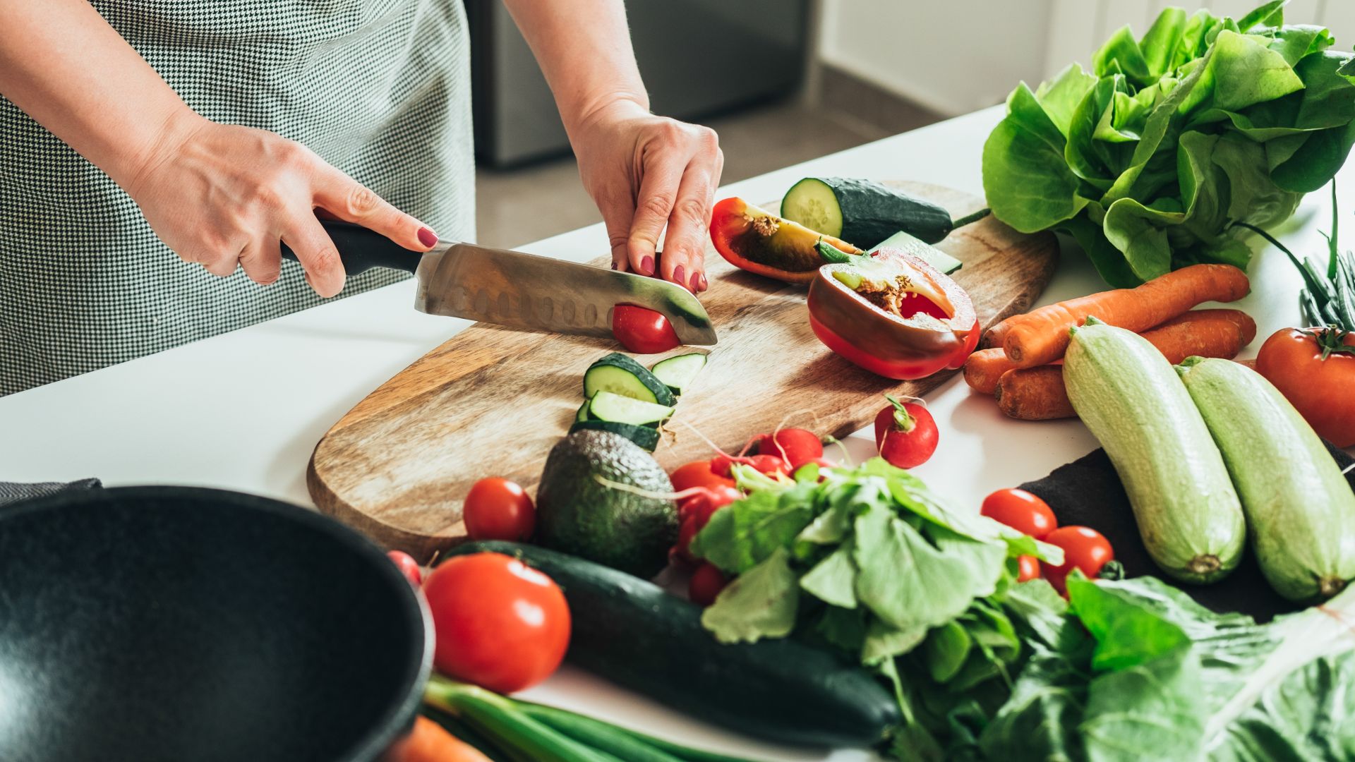 Frau schneidet Gemüse auf einem Brett
