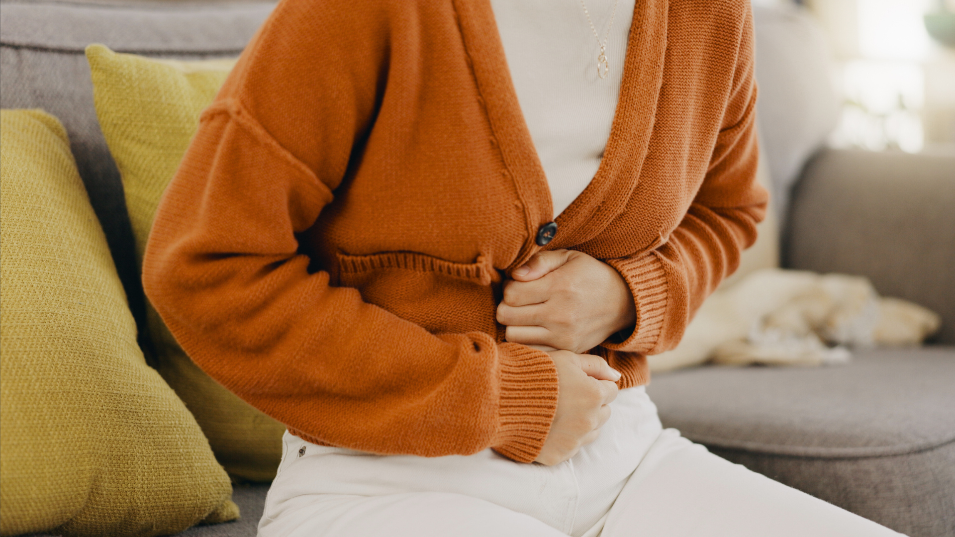 Frau hält sich vor Bauchschmerzen den Bauch