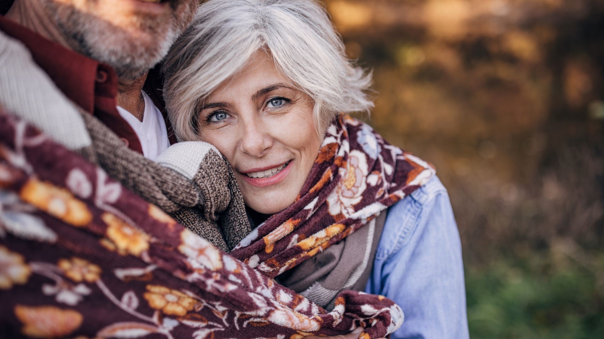 Frau mittleren Alters schaut lächelnd in die Kamera