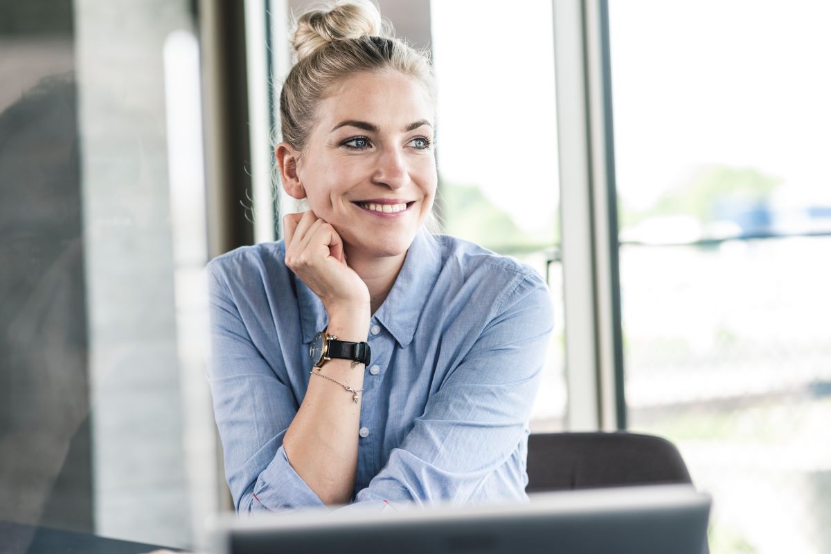 Frau sitzt im Büro und lächelt