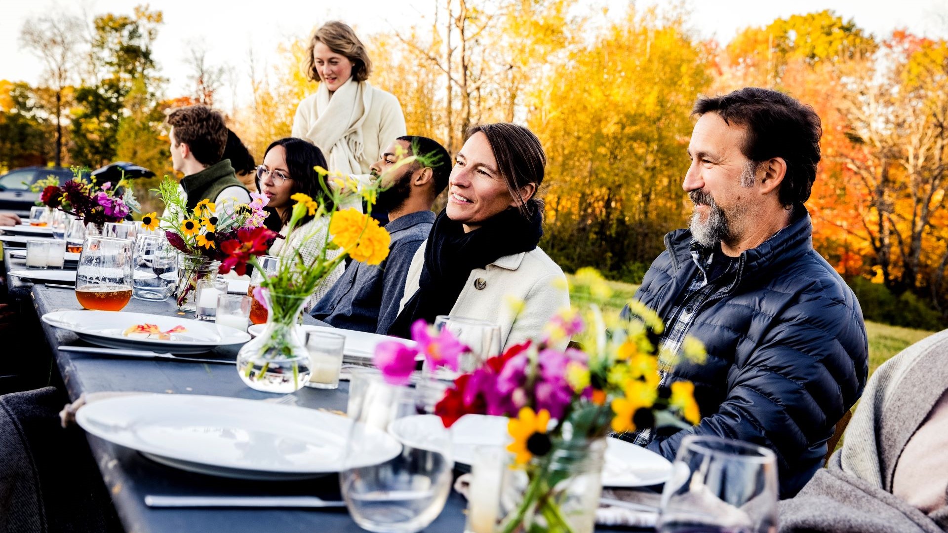 Frauen und Männer sitzen an einem gedeckten Tisch
