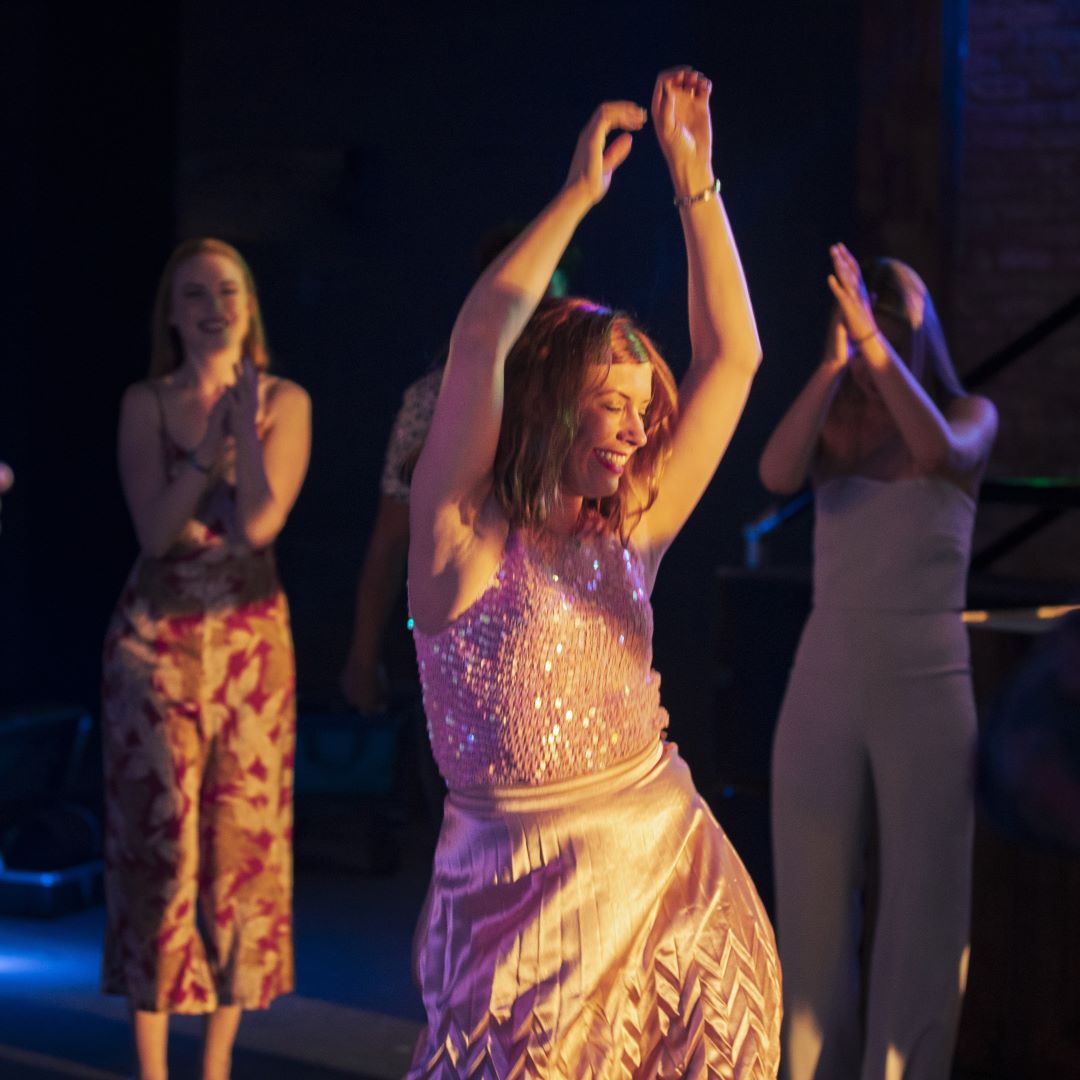 Frau tanzt und schwingt die Arme nach oben